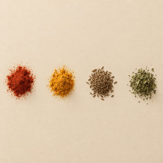 Häufchen von Paprika, Kurkuma, Kreuzkümmel und getrockneten Kräutern